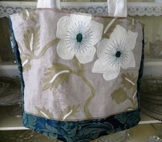 a bag with white flowers on it sitting on a shelf