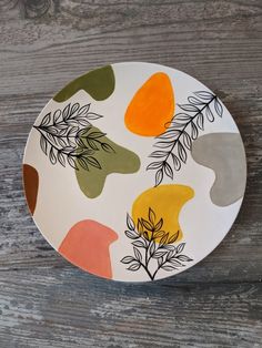 a white plate with leaves painted on it