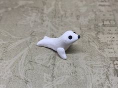 a small white stuffed animal laying on top of a bed