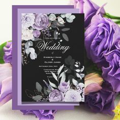 wedding card with purple flowers and greenery on the front, next to it is a black background