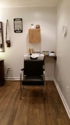 a chair sitting in the middle of a room next to a sink and mirror on the wall