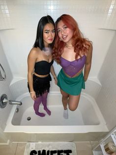 two young women standing in a bath tub