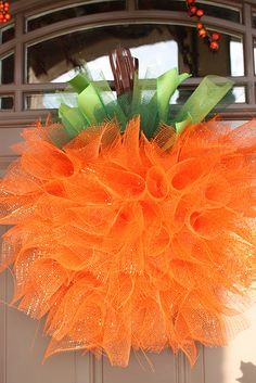 an orange wreath hanging on the front door