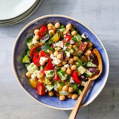 a blue bowl filled with vegetables and chickpeas