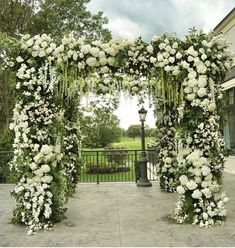 an outdoor wedding ceremony with white flowers and greenery