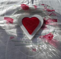 a heart shaped glass plate sitting on top of a table