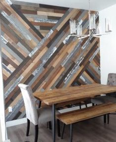 a dining room table with two benches and a wall made out of wood planks