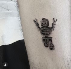 a small skeleton tattoo on the arm