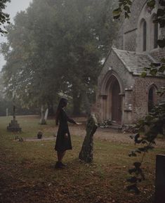 a woman standing in front of a cemetery holding the hand of another person's hand