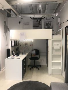 an office with a desk, chair and shelves on the wall in front of it