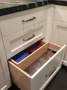 an open drawer in the middle of a kitchen