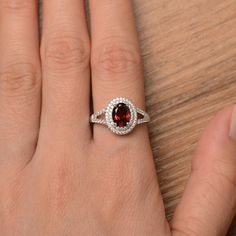 It is a natural garnet ring. The main stone is 6mm*8mm oval cut, weight about 1.73 carats. The basic metal is sterling silver and plated with rhodium. To change the metal to a solid gold (white/rose) or platinum is also available, please ask for a quotation if you want. You can also go to my shop Home for more elegant rings: https://www.etsy.com/shop/godjewelry?ref=hdr_shop_menu More garnet rings: https://www.etsy.com/shop/godjewelry?ref=seller-platform-mcnav&section_id=20709242 Customizatio Red Oval Halo Ring, Oval Garnet Jewelry With Halo Setting, Oval Garnet Ring With Halo Setting, Rainbow Topaz Ring, Wedding Rings Emerald Cut, Red Gemstone Ring, Oval Halo Engagement Ring, January Birthstone Rings, Double Halo Engagement Ring