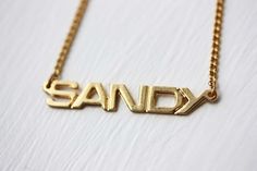 This is an awesome vintage name necklace from about the 70s! It is 14K Gold Plated and has never been worn.The name is about 1.5" wide.Model shown wearing “Marie” name necklace.NOTE: This CAN NOT be custom made. They are vintage, thus you will receive the exact same name in the photo above. We have lots of vintage name jewelry in the shop! You can see them all here at this link:https://www.etsy.com/shop/diamentdesigns/search?search_query=name&order=date_desc&view_type=gallery&ref=sho Vintage Personalized Nameplate Necklace, Personalized Vintage Nameplate Necklace, Vintage Nameplate Necklaces, Vintage Custom Name Jewelry Nameplate, Vintage Custom Nameplate Jewelry, Vintage Custom Name Nameplate Jewelry, Vintage Gold Name Necklace, Vintage Gold Necklace With Name Detail, Vintage Custom Name Necklace For Anniversary