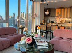 a living room filled with furniture and large windows