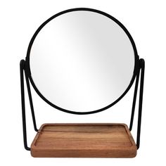 a round mirror sitting on top of a wooden tray next to a mirror with black metal frame