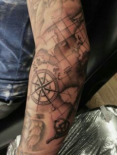 a man with a compass tattoo on his arm