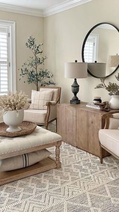 a living room filled with furniture and a large round mirror on the wall above it