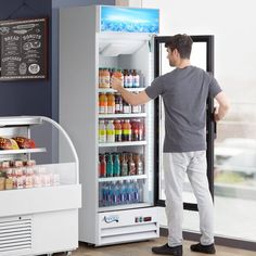 a man standing in front of an open refrigerator filled with drinks and juices on wheels