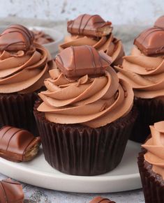 chocolate cupcakes with peanut butter frosting on a white plate and title overlay reads nutella bueno cupcakes