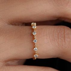 a woman's hand with a diamond ring on top of her finger and the band is