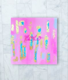 a pink and gold painting with the word love spelled in cursive writing on it