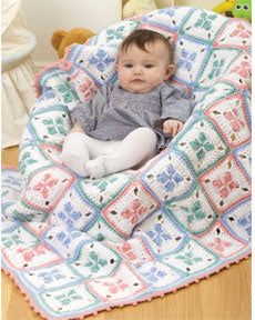 a baby is sitting in a crocheted blanket