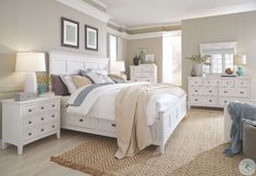 a white bed sitting in a bedroom next to a dresser and mirror on top of a wooden floor