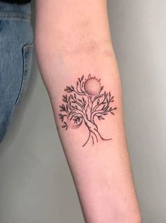 a small tree tattoo on the arm