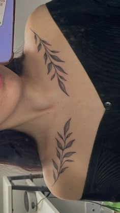 a woman with a tattoo on her chest is looking at her cell phone and smiling