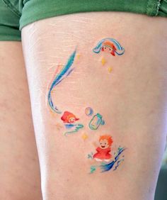 a woman's thigh with some tattoos on it and an image of a fish in the water