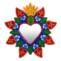 a heart shaped mirror with flowers and leaves on the border, hanging from a wall