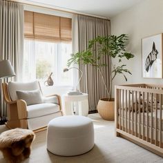 a baby's room with a crib, rocking chair and large potted plant