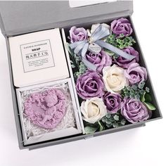 an open box with purple and white flowers in it