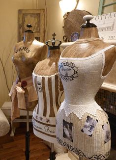 three mannequins are sitting on display in a room with wood flooring