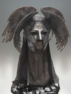 a mask with wings on top of it and a headdress in the middle