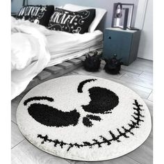 a bedroom with a bed and a rug that looks like a skeleton face on the floor