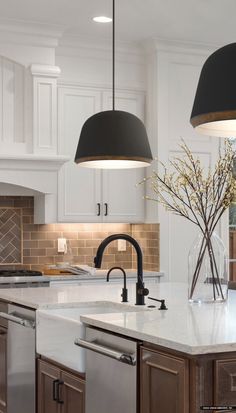 a kitchen with two pendant lights over the sink