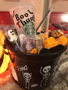 a starbucks cup filled with halloween treats on top of a bed