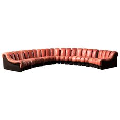 a curved leather couch with black legs