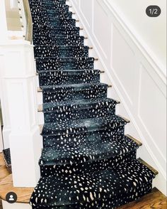 the stairs are painted with black and white spots on them, along with wood flooring