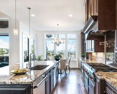 a large kitchen with marble counter tops and wooden cabinets, along with an island in the middle