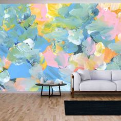 a living room with a couch, coffee table and large painting on the wall behind it