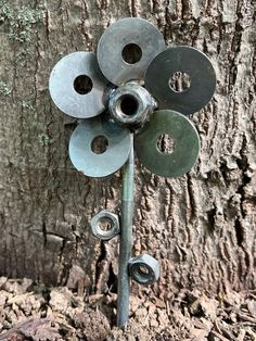 there is a metal sculpture on the side of a tree