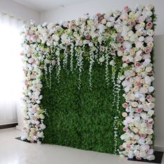 an artificial flower wall with white and pink flowers