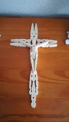 a cross made out of white plastic on top of a wooden table