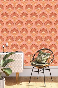 an orange and pink wallpaper in a room with a chair, potted plant and side table