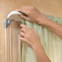 a person using a window sealer on a curtain