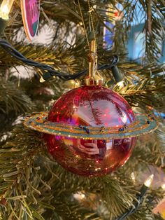 a red ornament hanging from a christmas tree