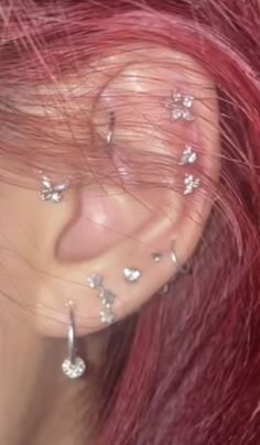 a woman with red hair and piercings on her ear