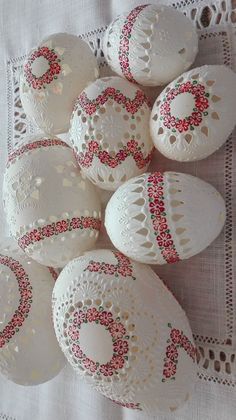 some white and red decorated eggs on a doily